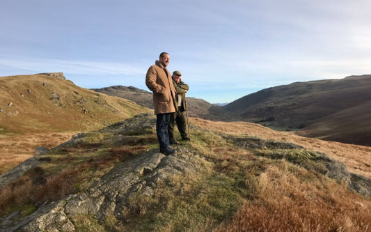 Man wearing a vintage shearling leather jacket standing on a hill in the British countryside — representing craftsmanship, individuality, and timeless style by Revive & Restore Vintage.