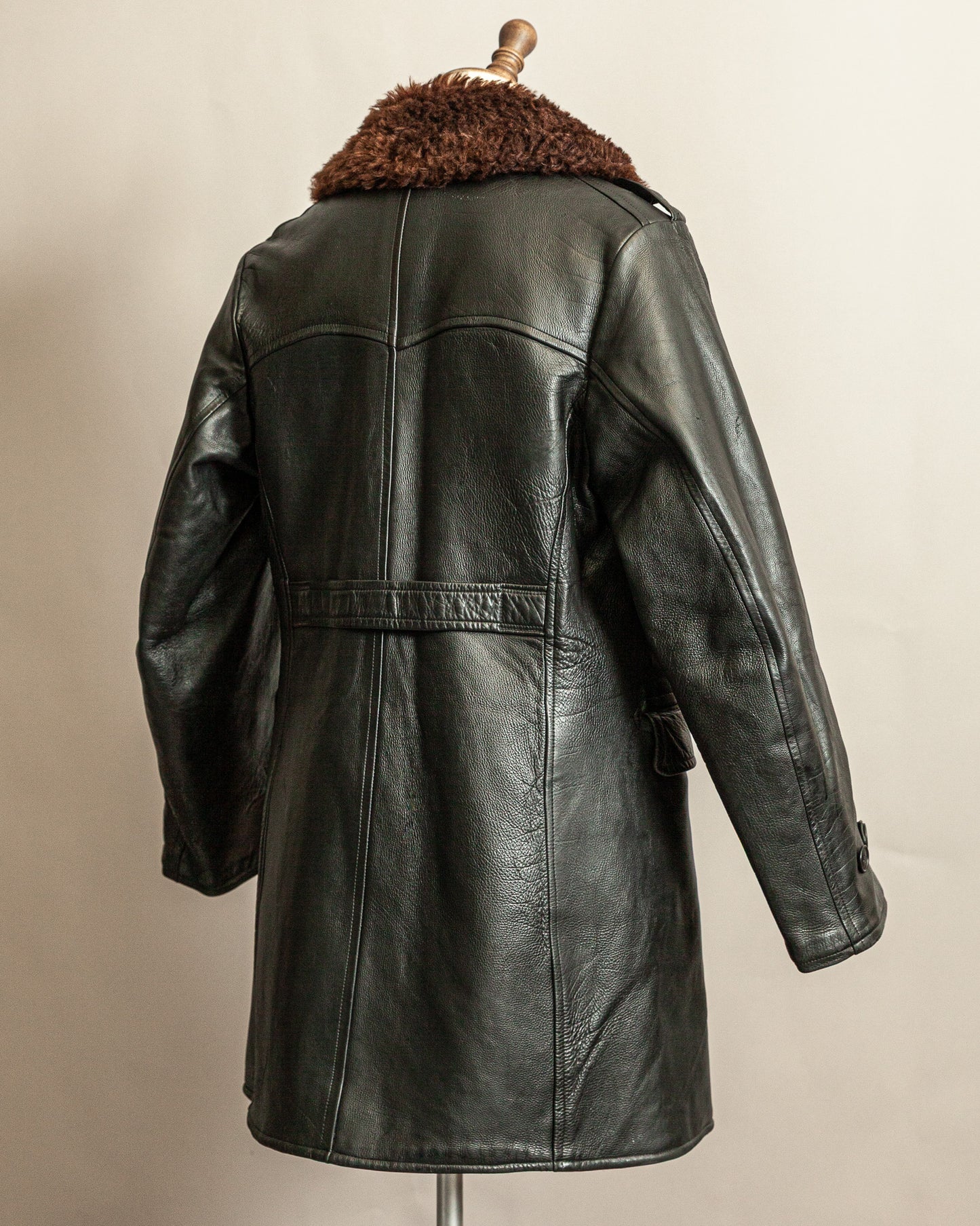 Swedish Military 1940s Black leather Trench coat with a brown wool collar on a mannequin against a beige background