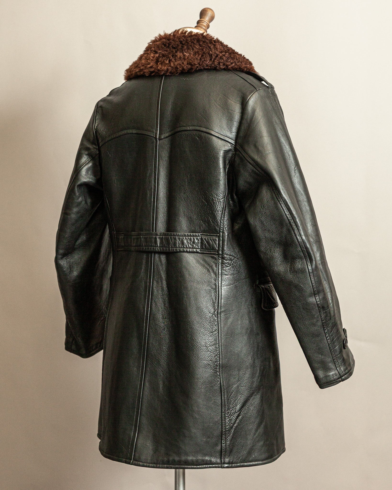 Swedish Military 1940s Black leather Trench coat with a brown wool collar on a mannequin against a beige background
