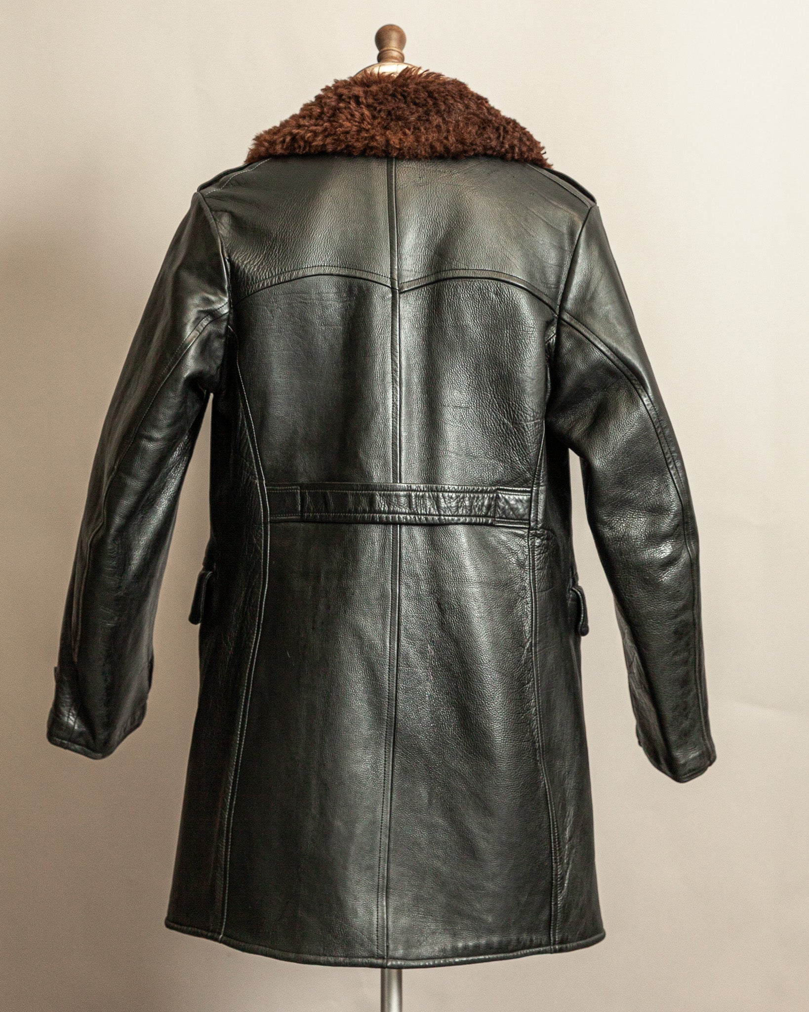 Swedish Military 1940s Black leather Trench coat with a brown wool collar on a mannequin against a beige background