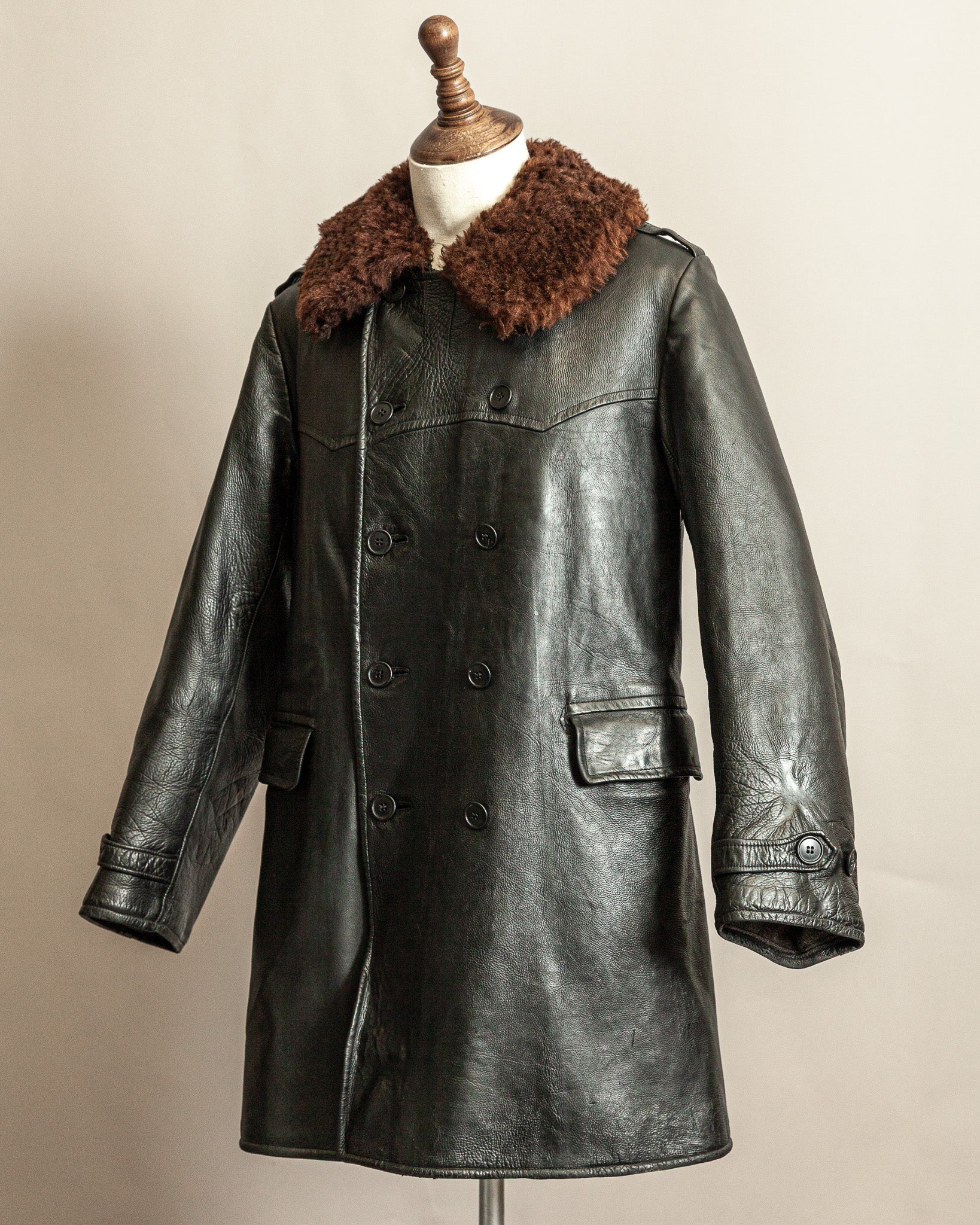 Swedish WW2 Black Goatskin leather vintage army trench coat with real wool collar on a mannequin against a beige background