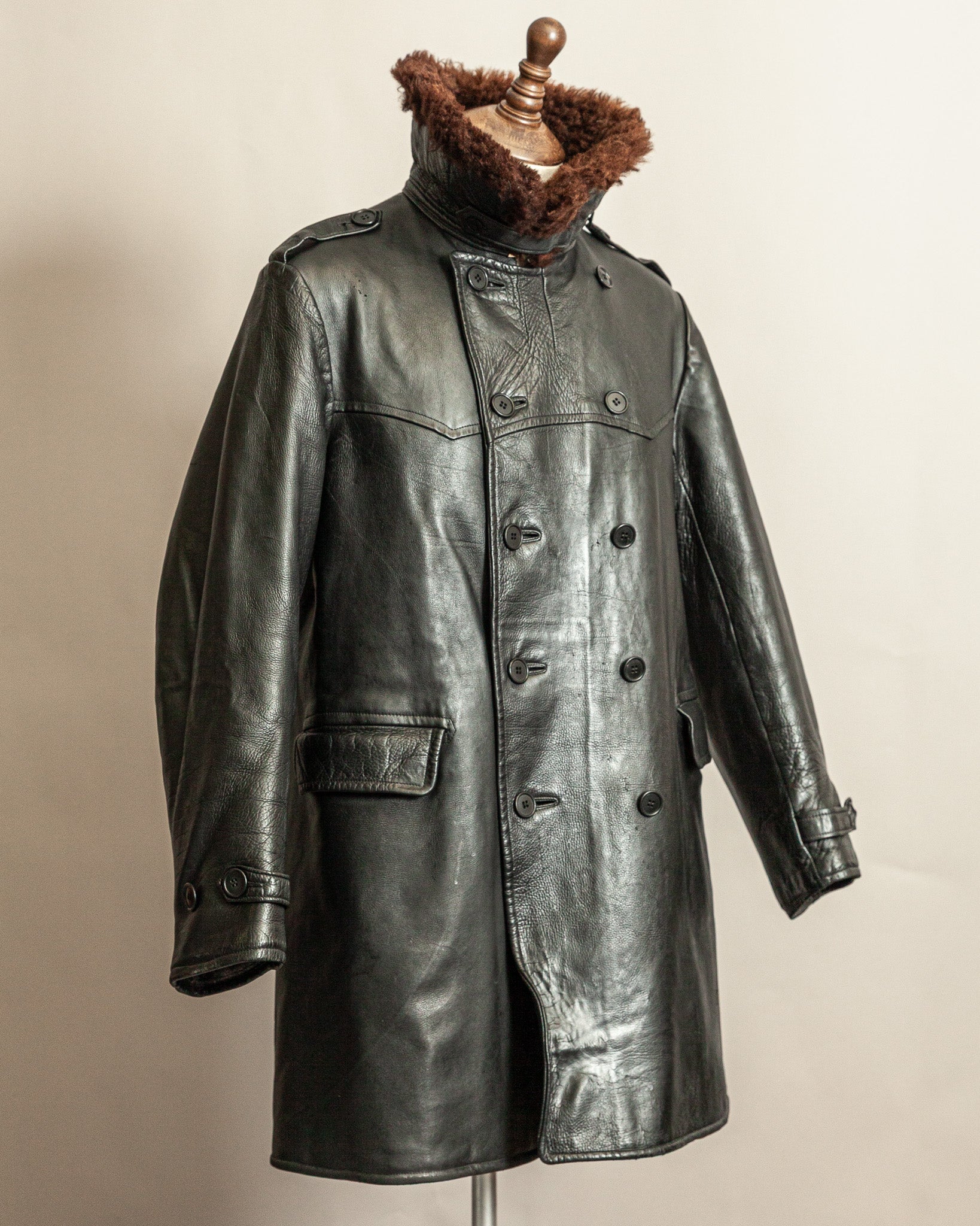Swedish WW2 Black Goatskin leather vintage army trench coat with real wool collar on a mannequin against a beige background