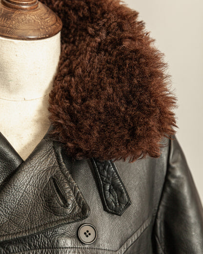 Black leather jacket with a brown fur collar on a mannequin.