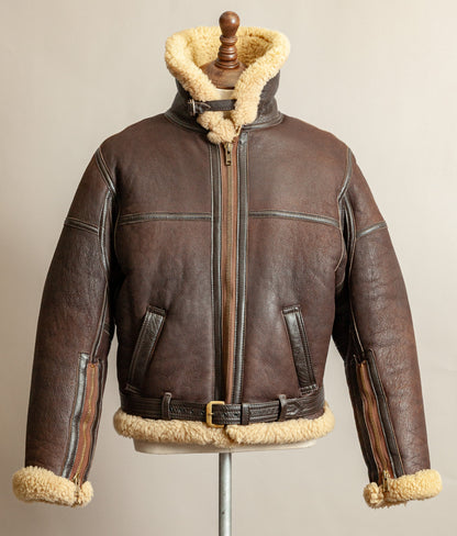 1980s Top Stitch Irvin-pattern sheepskin flying jacket – front view with collar fastened and standing high, showing patina and seam construction.