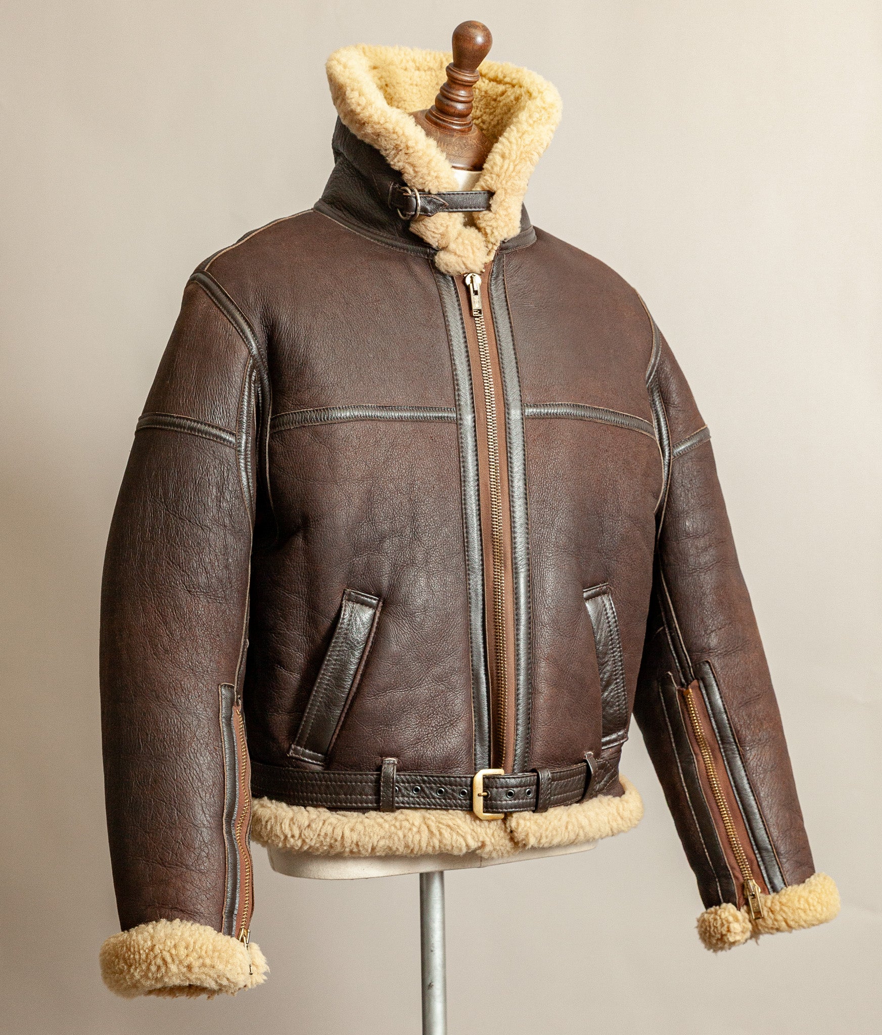 1980s Top Stitch Irvin-pattern sheepskin flying jacket, front view left side of jacket on an angle showing the collar standing high, also colours of brown shaded patina and seam construction.
