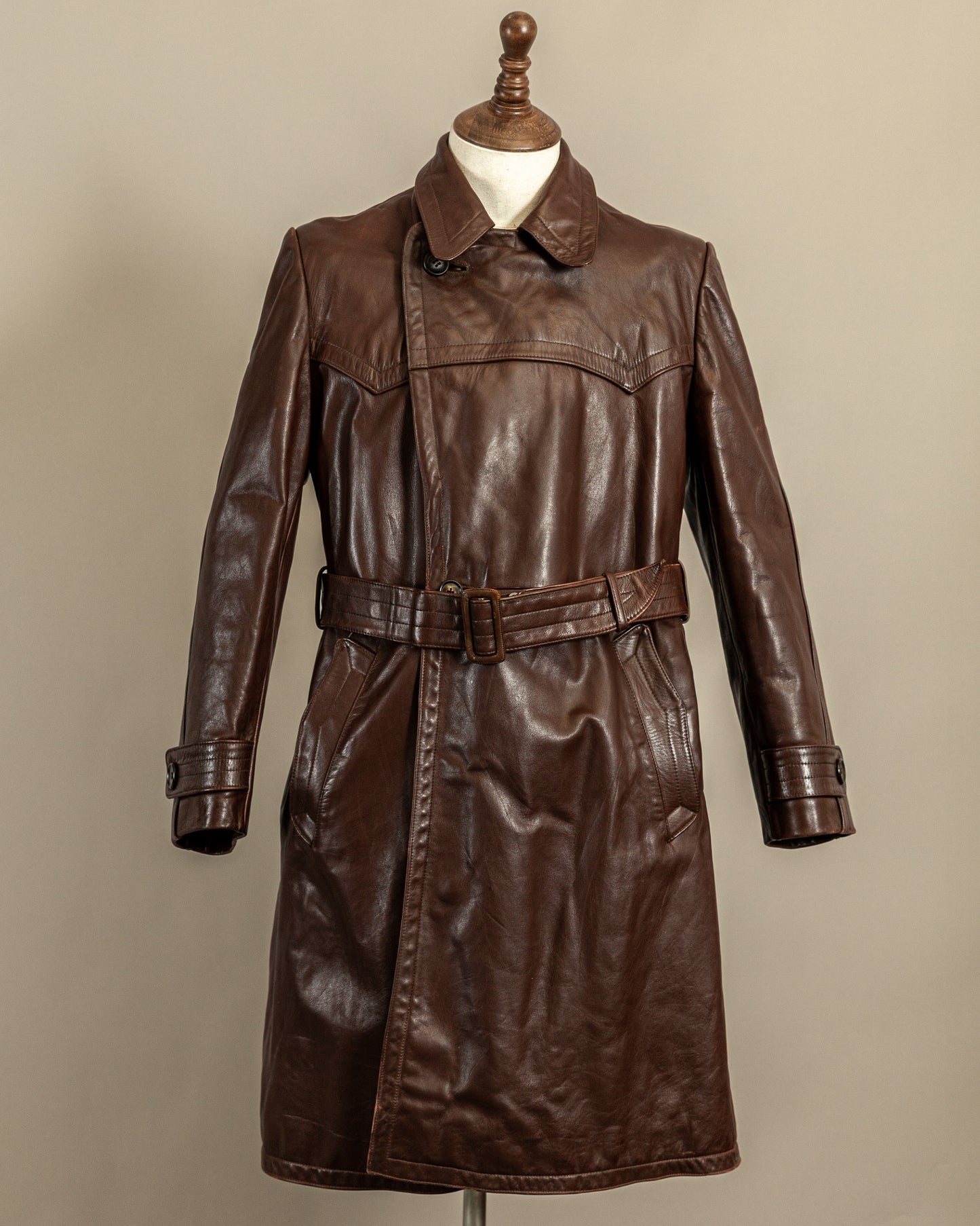 Front view of a vintage 1940s German officer private purchase leather trench coat in heavy brown horsehide with belted waist and long Ledermantel silhouette.