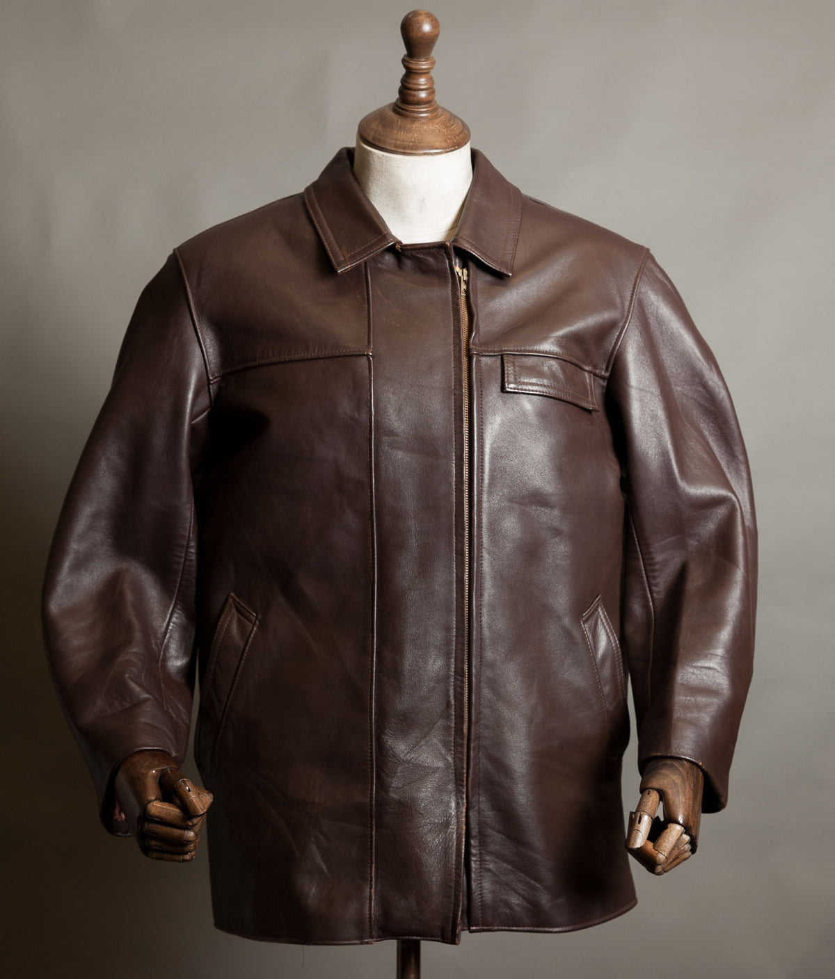 Vintage 1950s French dark brown leather work jacket by Cuiram Paris with shirt collar and Éclair zip, on a wooden mannequin