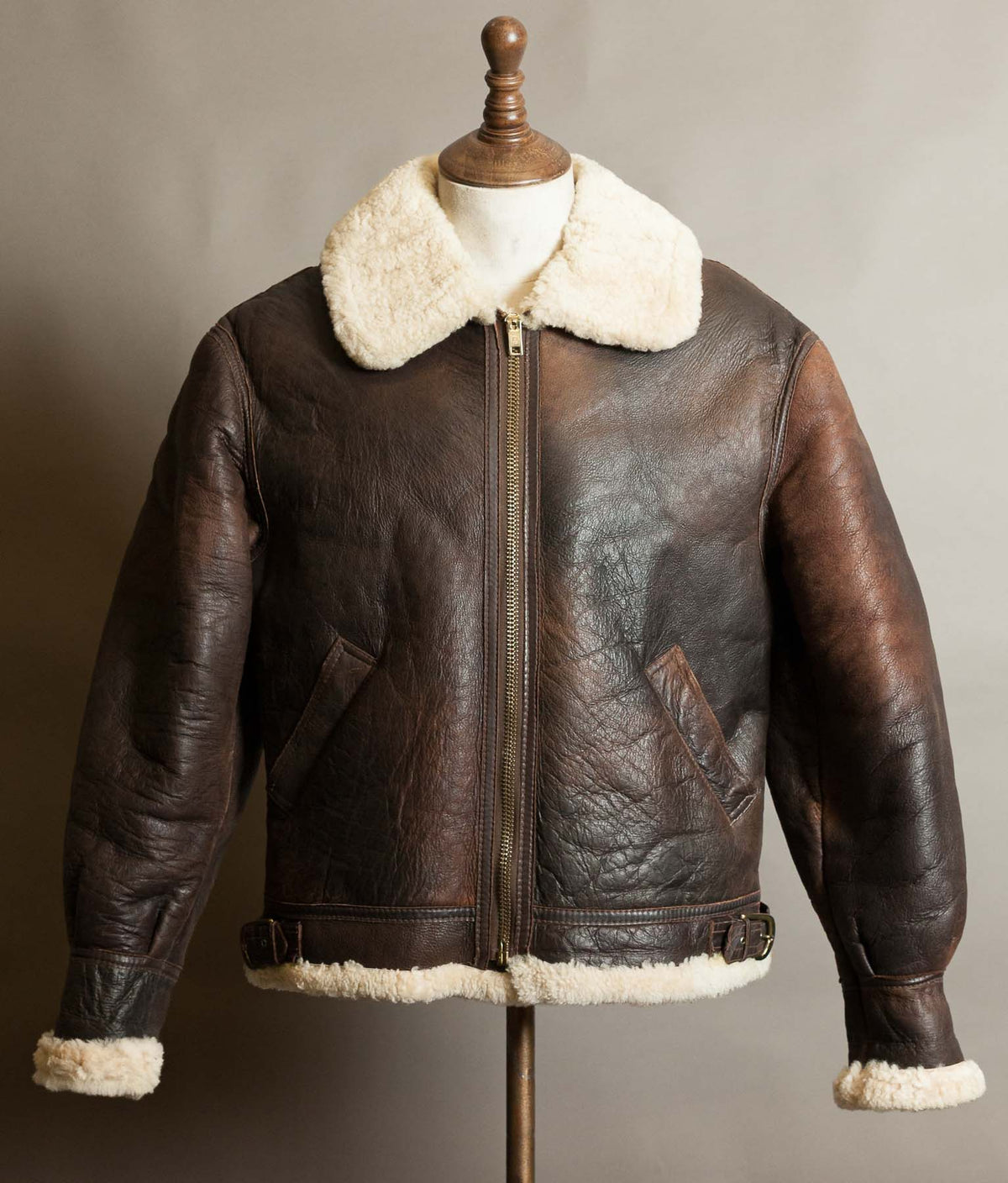 Vintage 1980s B-3 sheepskin flying jacket in brown with a cream shearling collar, brass zip and buckled waist, USAAF pattern