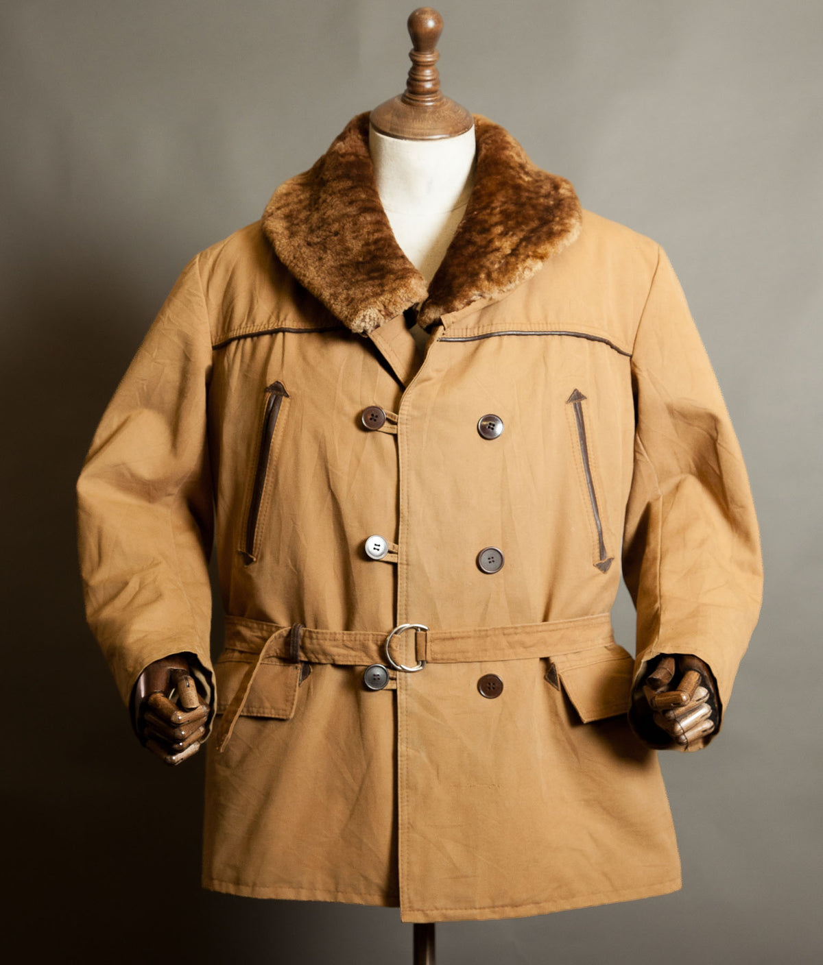 Vintage 1950s French canadienne coat in tan canvas with a brown mouton shawl collar, double-breasted buttons, leather trim and belted waist