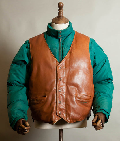 Front of a vintage Schott NYC 126 down jacket with tan leather front panels, Schott snaps and green goose down sleeves, made in USA