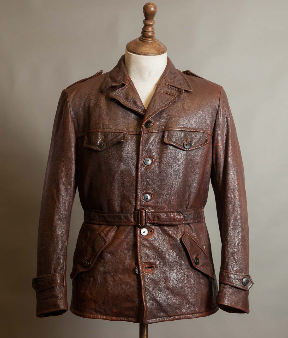 Front of a vintage 1940s-50s Swedish brown goatskin leather jacket with notched collar, four flap pockets, leather belt and rich oxblood patina